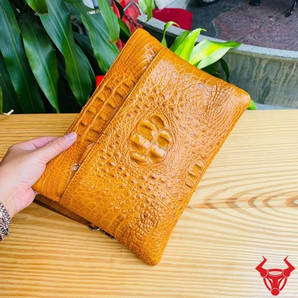 Clutch cầm tay da gù cá sấu CBDA4 màu vàng cam nhiều ngăn tiện dụng.