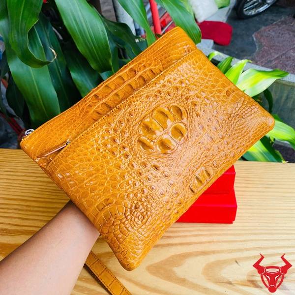 Clutch nam da gù cá sấu CBDA4 màu vàng cam chế tác tinh xảo và sang trọng.