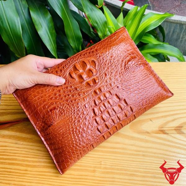 Clutch Nam Da Gù Cá Sấu CBCA4 Màu Nâu Đỏ Đẳng Cấp Clutch cầm tay da gù cá sấu CBCA4 màu nâu đỏ với vân da tự nhiên nổi bật.
