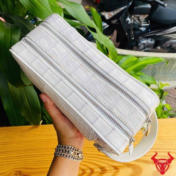 Túi clutch da bụng cá sấu CGA8 màu bạch tạng sang trọng với thiết kế hai ngăn khóa kéo.
