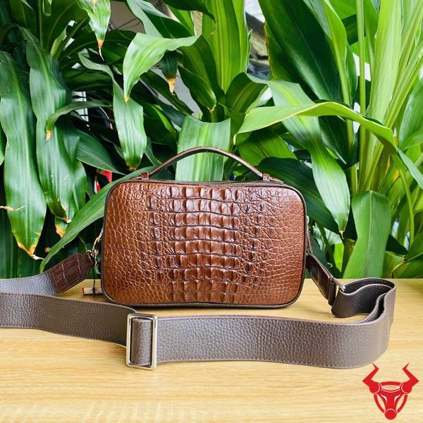 Clutch Golf da gù cá sấu CJA4 màu nâu đất với vân da tự nhiên nổi bật.