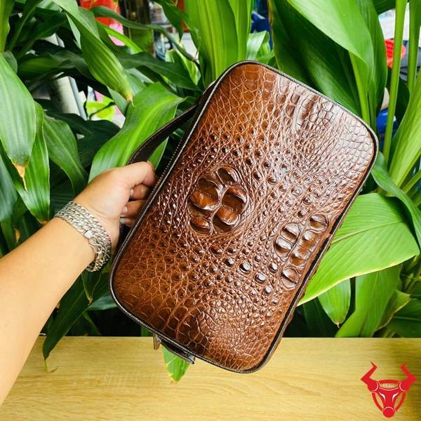 Clutch nam da gù cá sấu CJA4 màu nâu đất được chế tác tỉ mỉ và sang trọng.
